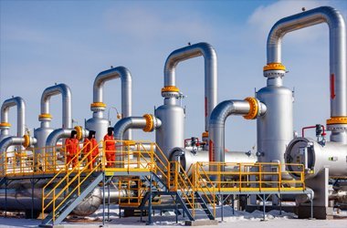 Workers in FR clothing overseeing large oil and gas pipeline operations.